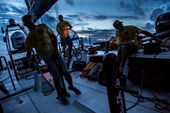 Onboard Abu Dhabi Ocean Racing – Daryl Wislang, Luke Parko Parkinson, and Ian Walker lean around the headsail to spy on Alvimedica at dusk - Leg six to Newport – Volvo Ocean Race 2015 © Matt Knighton/Abu Dhabi Ocean Racing